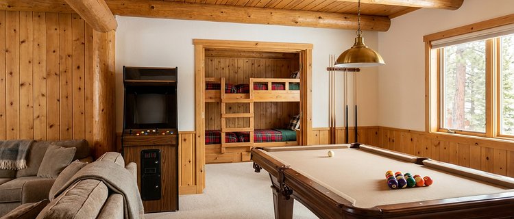 Game room with a pool table and arcade cabinet opening onto a bunk room in a Big Bear group cabin